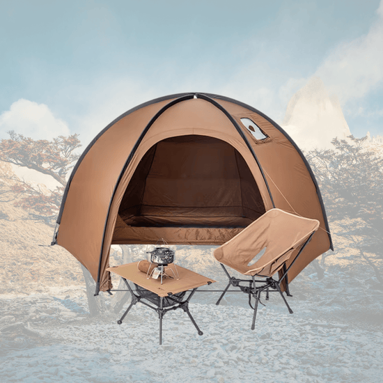 Camping tent with table and chair set against a mountainous landscape