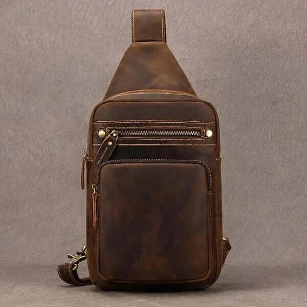 Best sling bag with carrying strap, top zipper opening, front view, pointed top shape, gray background.