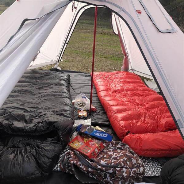 Inside view of ultralight hot tent with sleeping bags and supplies, ideal for winter camping and bushcraft, featuring durable 210D Oxford Cloth.