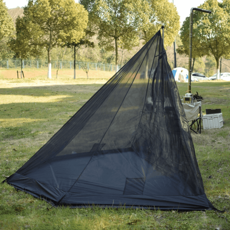 Black inner tent for tipi tent shown on a park with trees and grass in the background.