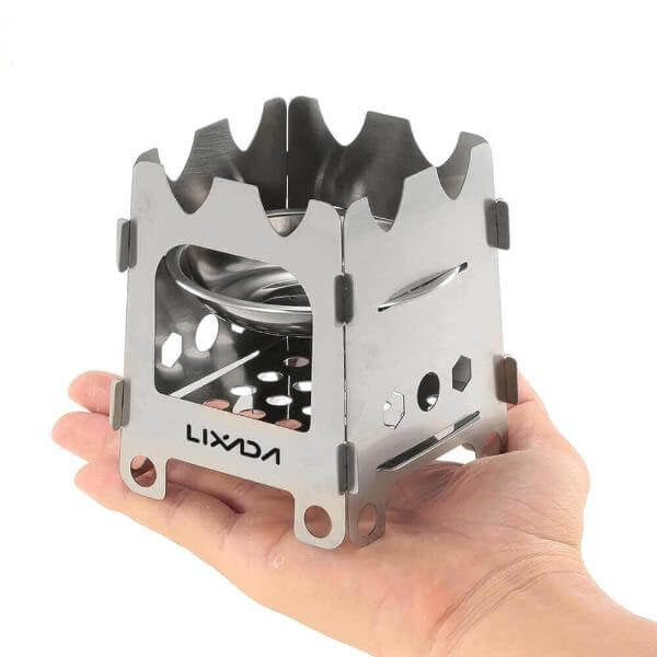 Titanium portable ultralight folding wood stove, ideal for hot tents, backpacking, and camping, held in hand showing its compact size.
