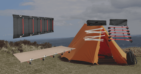 Camp folding bed setup alongside an orange tent in a scenic outdoor location.