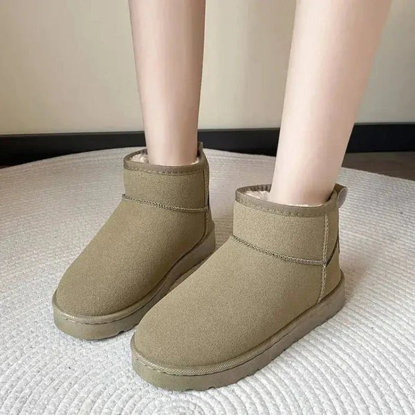 Woman wearing Australian made Ugg boots, classic round-toe design, flat heel, cozy cotton interior, offering warmth and comfort.