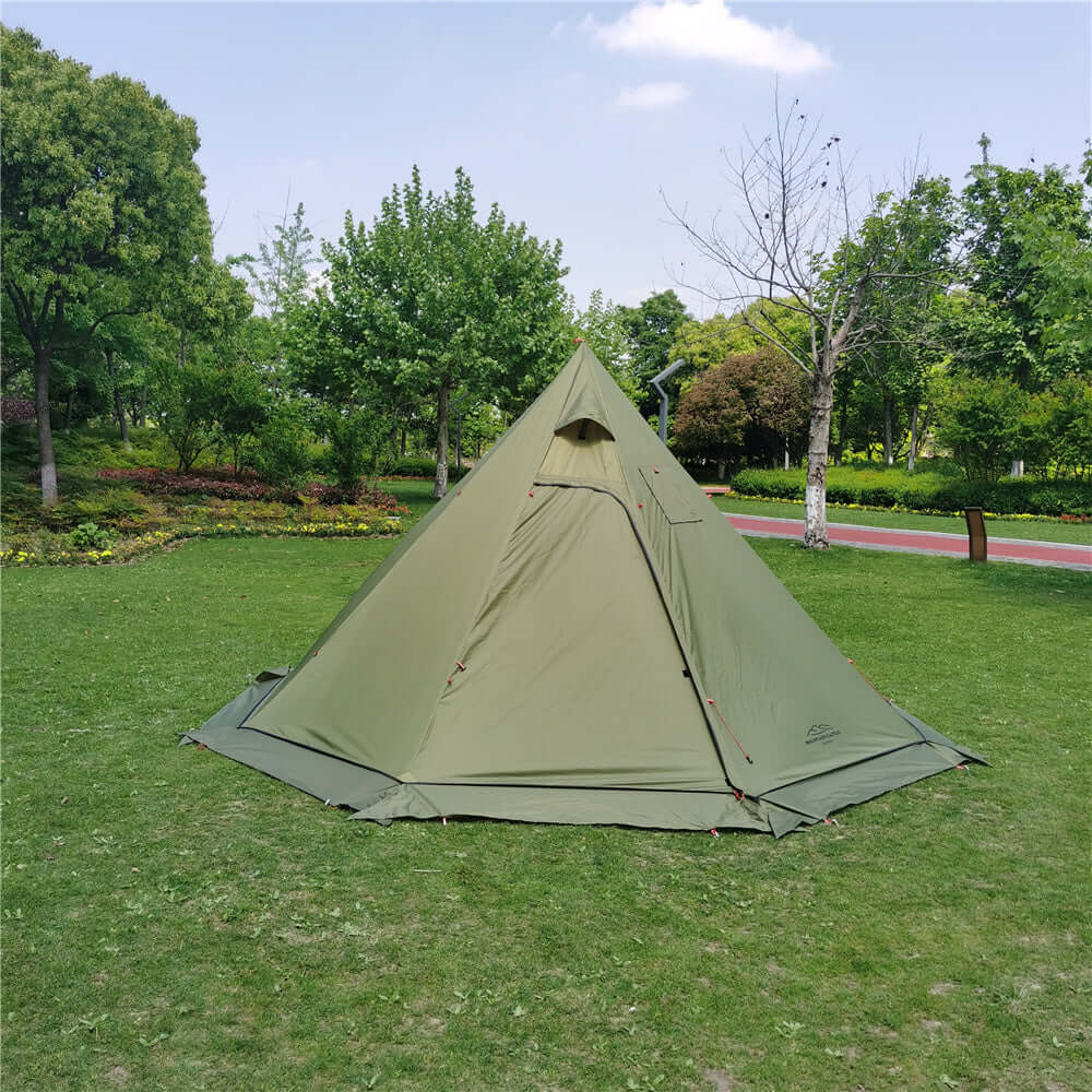 Green winter tent with stove set up in a lush park, showcasing its spacious interior and sturdy design for all-season camping.