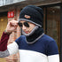 Man wearing a black wool beanie and matching neck warmer, styled with sunglasses, showcasing cozy winter fashion.