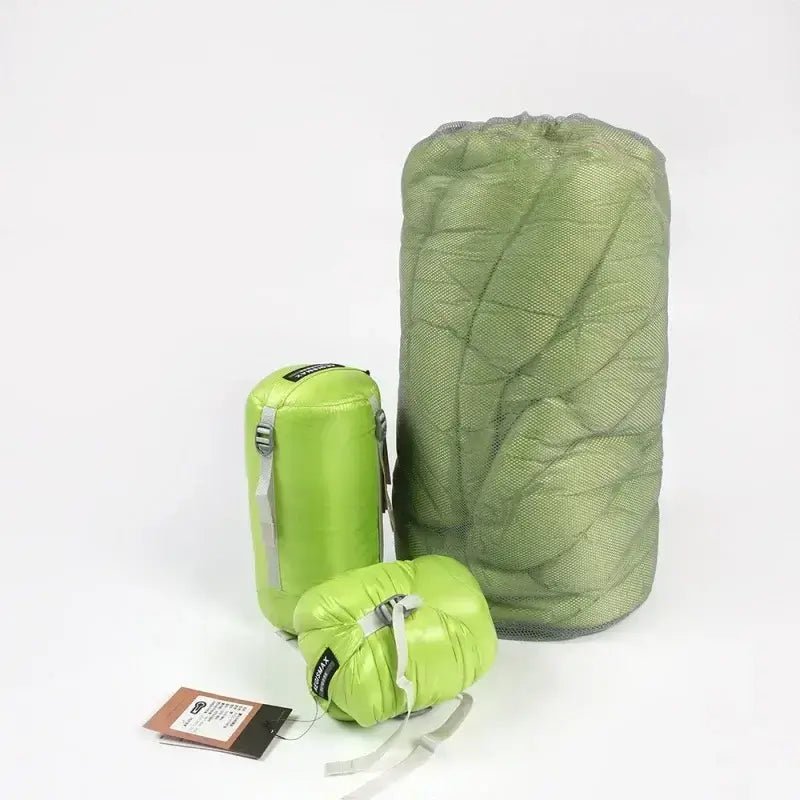 Green camping sleeping bags in multiple sizes, perfect for comfortable and warm 3-season outdoor use, shown packed and compact.