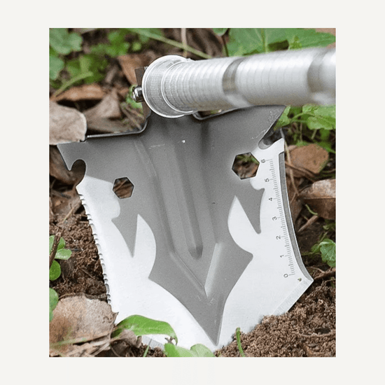 Close-up of a multifunctional camping shovel head with measuring scale, showcasing its heavy-duty design for outdoor use.