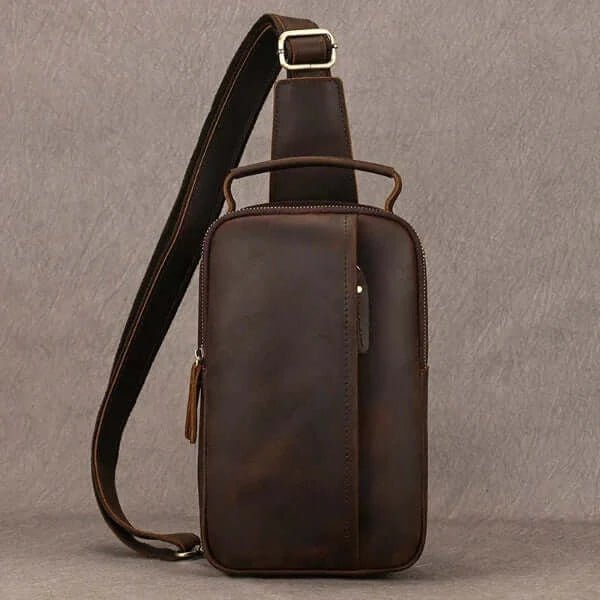 Best sling bag for men, brushed leather, carrying strap, metal buckle, top zipper opening, front view, white background.