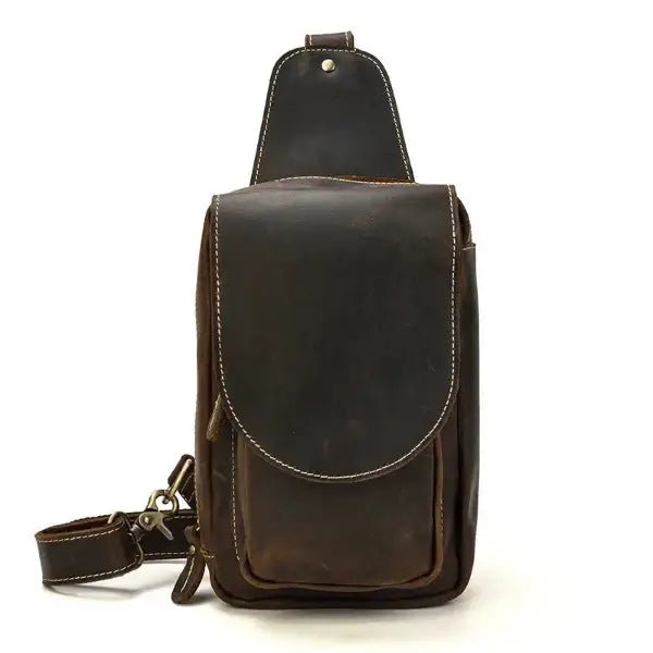 Small leather sling bag, brown, carrying strap, metal buckle, top zipper opening, front view, white background.