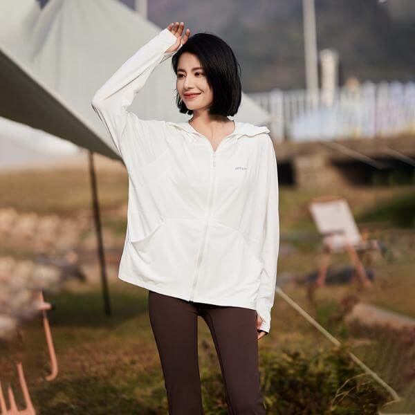 Woman wearing lightweight unisex sun protective hoodie jacket in white, perfect for summer with UPF 50+ fabric, by jimboree2020