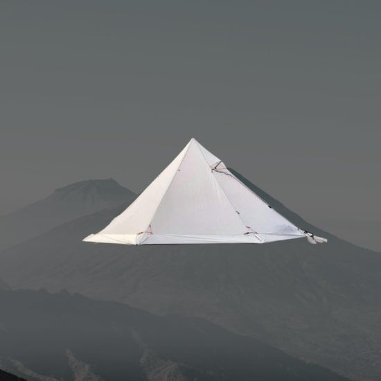 Ultralight white pyramid-shaped hot tent for winter camping, bushcraft, and backpacking with stove jack, ideal for harsh weather conditions.