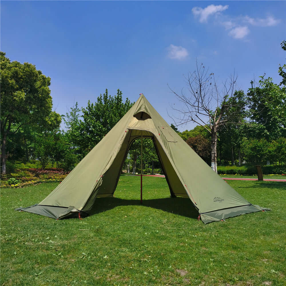 Green winter tent with stove setup for camping in a grassy park setting