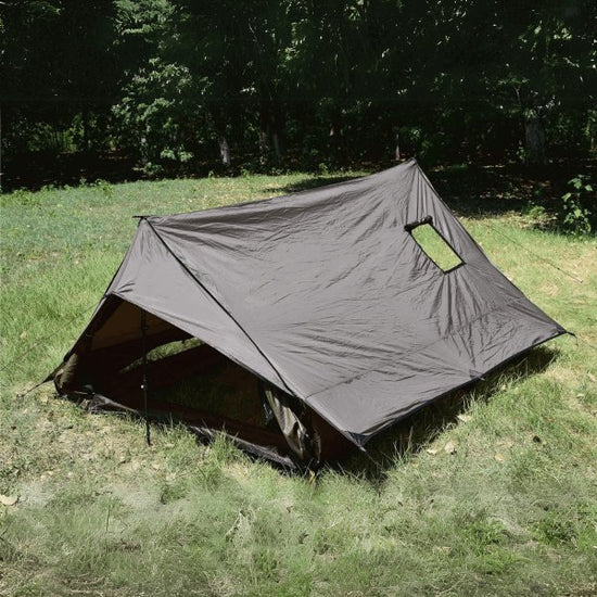 Ultralight backpacking tent set up on a grassy field, perfect for winter camping, accommodates 1-2 people.