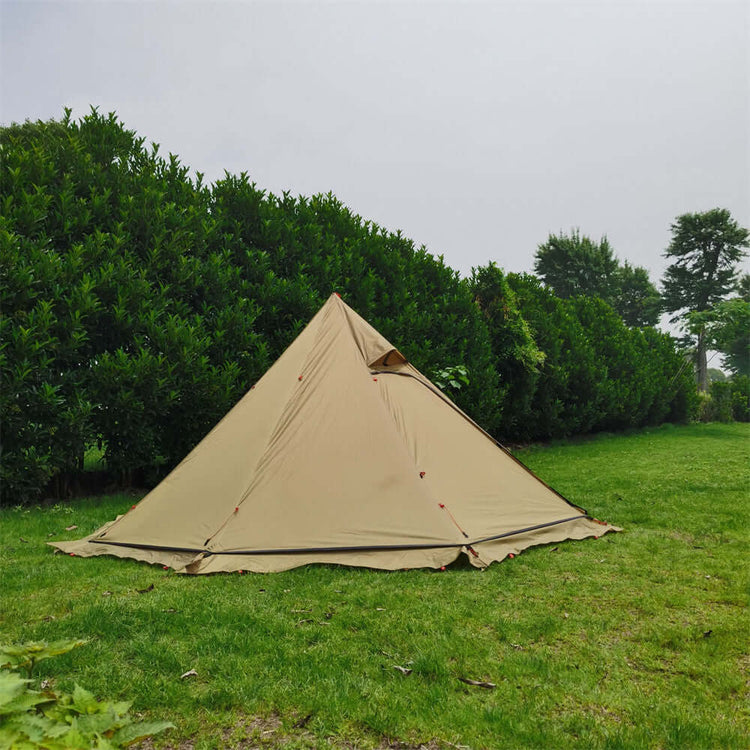 Large hot tent with stove setup on green lawn, perfect for winter camping.