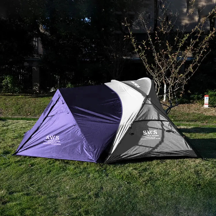 Backpacking tent with stove jack in bold purple and gray, positioned on grassy ground with trees behind. Eye-catching design built for warmth and wilderness performance.