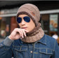 Man wearing a brown wool fisherman beanie and scarf with sunglasses and denim jacket