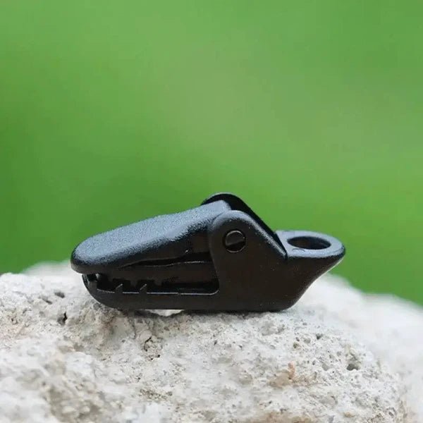 Black plastic clip buckle for securing tarpaulins, canopies, and awnings. Lightweight and strong rope clamp made of high-quality nylon plastic.