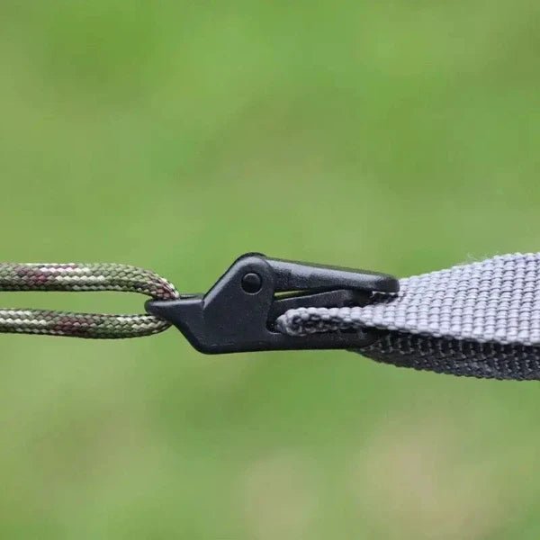 Plastic clip buckle securing rope and fabric, demonstrating tight grip and stronghold, ideal for camping tarps or tents.