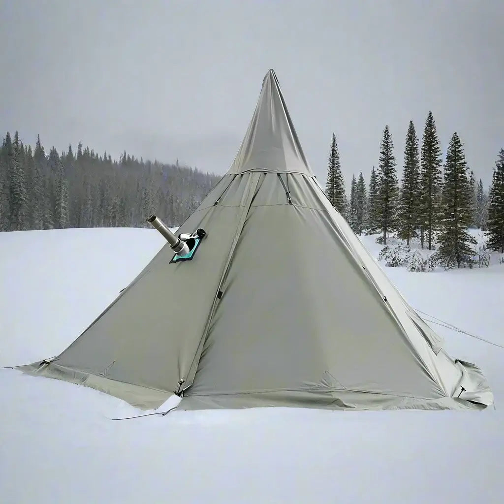 A large army green pyramid-shaped tent set up in a grassy field with mountains in the background.