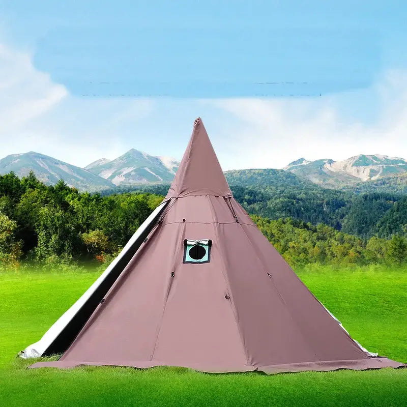 A spacious, pyramid-shaped tent with a smoke hole at the top, pitched on a grassy field with a scenic mountain backdrop.