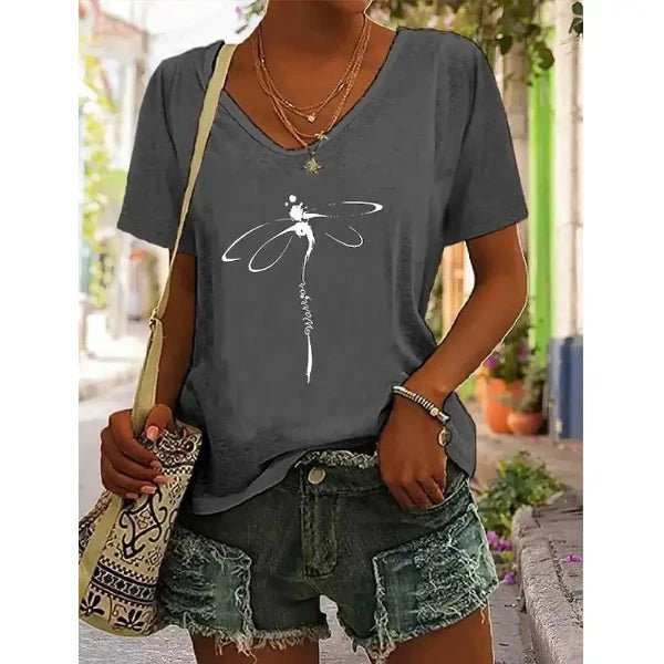 Woman wearing a V-neck graphic tee with a dragonfly design, teamed with distressed denim shorts, perfect for effortless summer style.