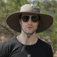 Man wearing gray wide brim bucket hat, perfect for safari and outdoor activities, providing sun protection and comfort.