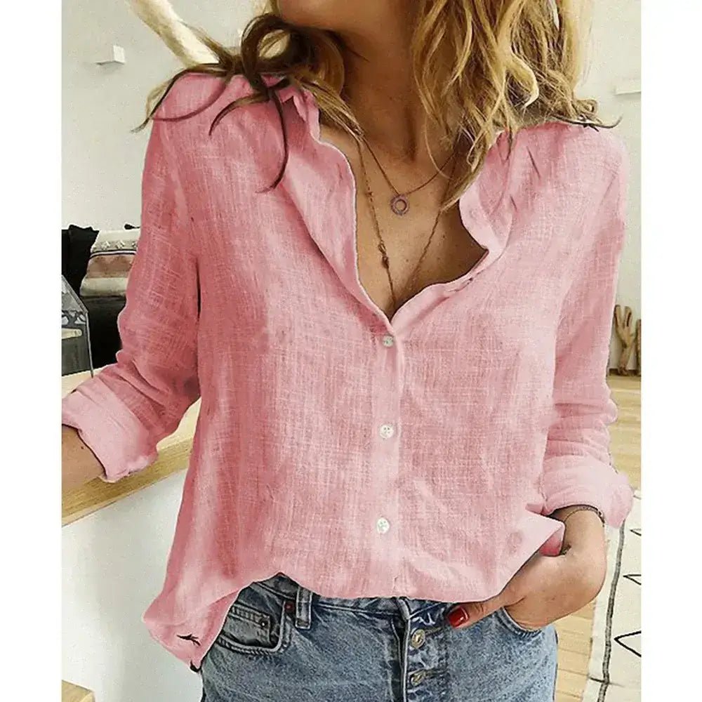 Woman wearing a pink cotton linen button-up shirt with roll-up sleeves and V-neck lapel collar, styled with casual denim jeans.