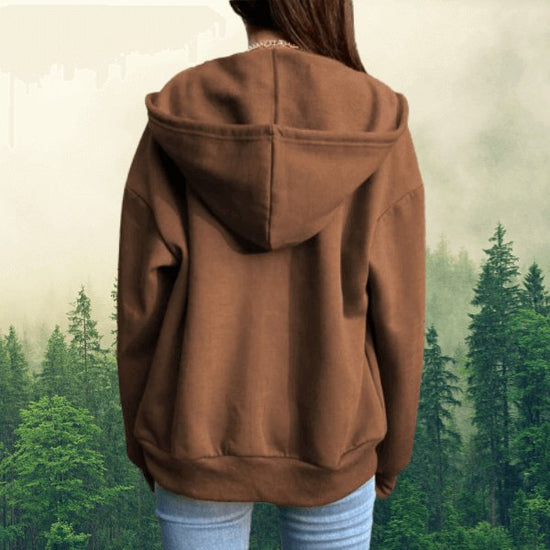 Woman in a brown long-sleeved casual hoodie with oversized hood and adjustable collar, showing the back in a forest background .