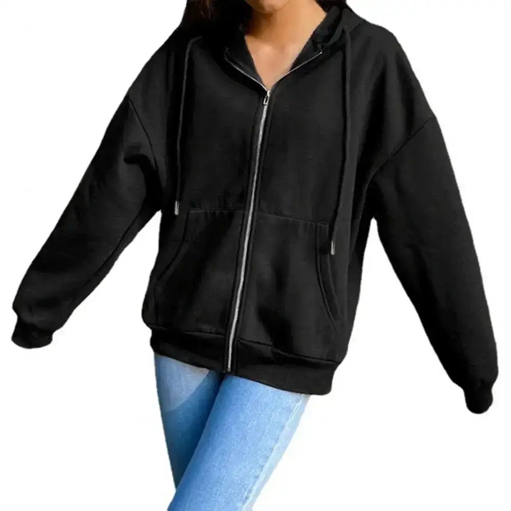 Woman wearing a black women sweatshirt jacket with an oversized hood and adjustable collar hoodie, paired with blue jeans