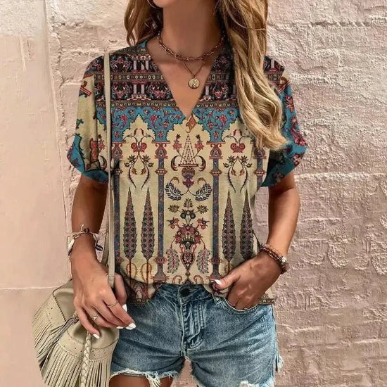 The best t-shirts for women, standing next to a wall in graphic tee and shorts, side bag, jewelry on waist and hands.