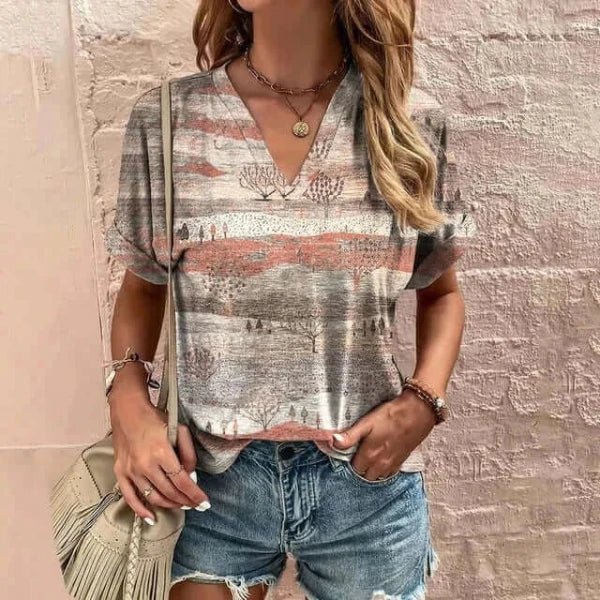 Best t-shirts for women, standing next to a wall in graphic tee and shorts, side bag, jewelry on waist and hands.