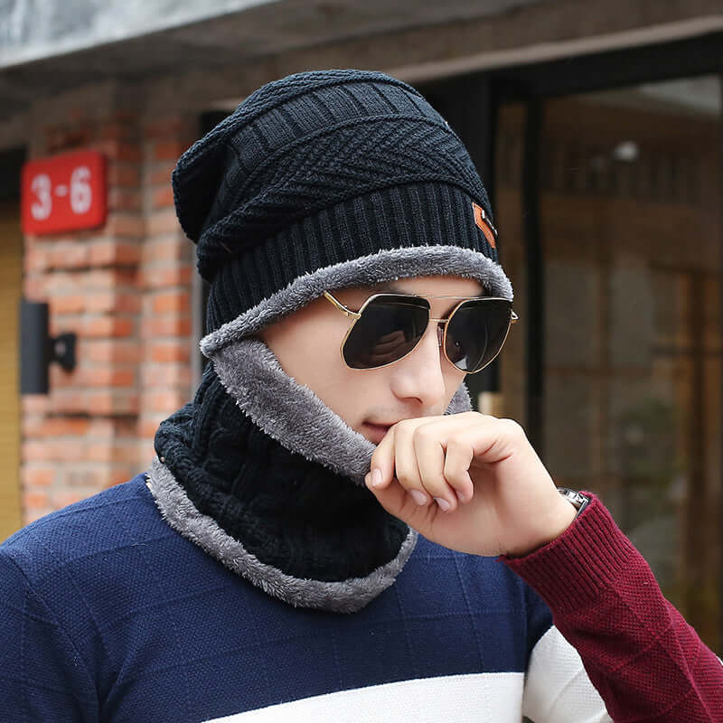 Man wearing a black wool slouch beanie and matching scarf, showcasing cozy fleece lining, perfect for winter warmth and style.